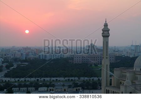 Sun Setting Over Manama City With The Minaret Of Al Fateh Grand Mosque In Foreground