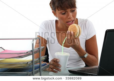 Kantoor werknemer met een snelle lunch achter haar computer