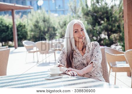 Blonde Girl Sitting At The Beach Restaurant Coffee