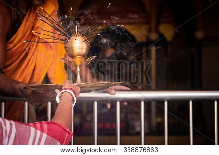 Indian Religious Woman Helps Her Husband In The Worship Of Deities Called Puja.
