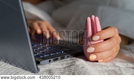A Woman Lies In Bed Holding A Clitoral Vibrator And Watching Porn On A Laptop. The Girl Has Sex Onli