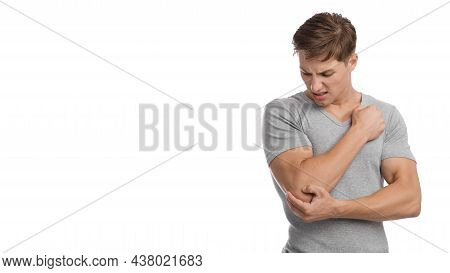 Despaired Millennial European Male Suffering From Elbow Pain, Presses Hand To Sore Spot