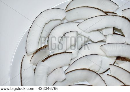 Slicing And Shavings Of Coconut On A White Plate