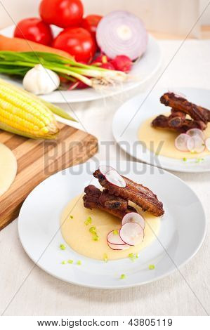 Ribbs หมูบนข้าวโพด Polenta ครีมเตียง