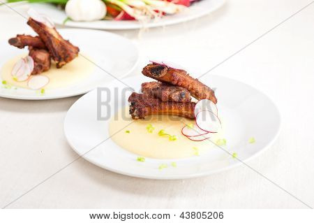 Ribbs หมูบนข้าวโพด Polenta ครีมเตียง