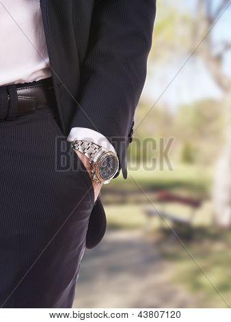 Mano dell'uomo d'affari in tasca con un orologio da polso.