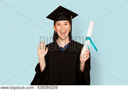 Woman wearing regalia holding her degree for graduation
