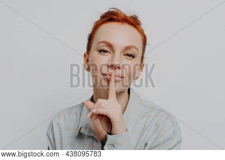 Close Up Of Young Redhead Woman Holding Finger On Lips, Asking To Be Quiet, Keep Something In Secret