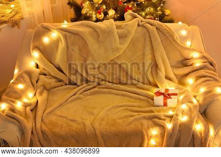 Festive Home interior - wew year or christmas decoration. At night, the room glows with festive lights. A lots of gifts and decorations. Winter holiday concept