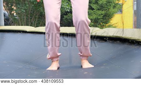 Young Woman Is Jumping On A Babut, A Close-up. Legs Float In The Air After Jumping On A Trampoline. 