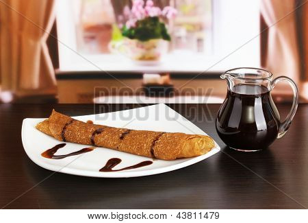 หวาน pancakes บนแผ่นกับนมข้นบนโต๊ะในห้อง