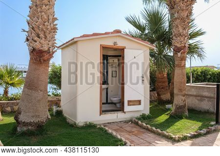 Beach Toilet Booth At The Resort With An Open Door. Brick Plastered Beach Toilet Building With Tiled