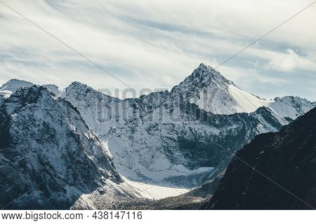 Great View To High Snowy Mountain Wall With Peaked Top Under Cirrus Clouds In Sky. Alpine Landscape 