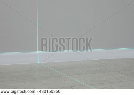 Cross Lines Of Laser Level On Wall And Floor Indoors