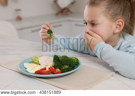 Cute Little Girl Covering Mouth And Refusing To Eat Dinner In Kitchen
