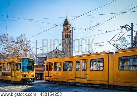 Budapest, Hungary, March 2020, View Of Two Tramways Passing By Saint Vincent De Paul Church By Meste