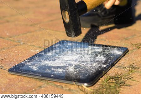 Close-up Image Of A Broken Screen On A Tablet And A Hammer