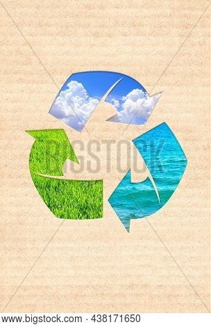 Arrows recycle symbol on cardboard texture. Vertical banner with eco paper texture and grass, clouds in blue sky, water. Paper cardboard background. Recycled carton material. Copy space for text