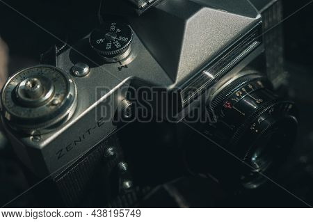 Soviet Film Camera Zenit-e With Industar 50-2 Lens. Tilted Composition, Close-up, Black Background