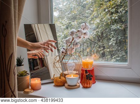 Girl Decorates The Window Sill In Her Room For The Holiday. She Made A Composition Of Mirror, Flower