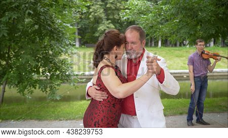 Positive Adult Friends Dancing Pair Dance In Garden. Elderly Couple Dancing Tango. Elderly Man And W