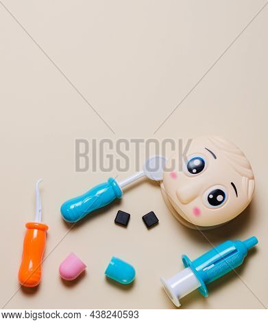 Childrens Set Of Dentist With Tools And Play Doll Head Mockup. Tablet For Recording. Copy Space Flat