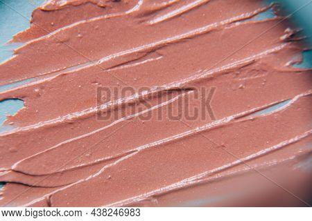 The Texture Of The Foundation Is Beige Under The Make-up On A Blue Background.