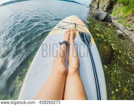 Young Women Having Fun Stand Up Paddling In The Sea. Sup. Red Hair Girl Training On Paddle Board Nea