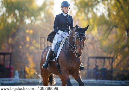 Teenage Girl Riding Horse On Equestrian Dressage Test In Autumn