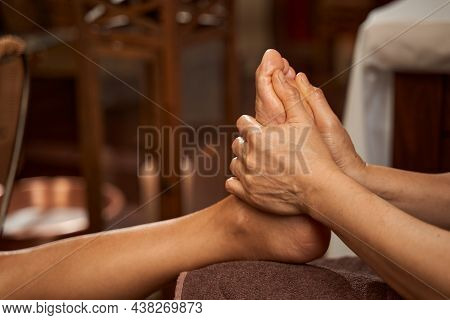 Skilled Reflexologist Performing Reflexology Massage Using Thumbs