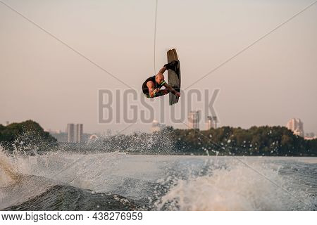 Energy Guy Holds Rope And Jumping And Flip With Wakeboard.