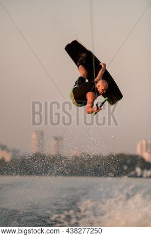 Strong Energy Man Jumping And Flips On Wakeboard Over Splashing Wave