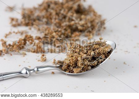 Spoon With Dried Wormwood Herb Isolated On White Background.