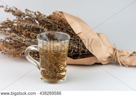 Herb Tea And Wormwood Twigs Wrapped In Brown Paper Close Up.