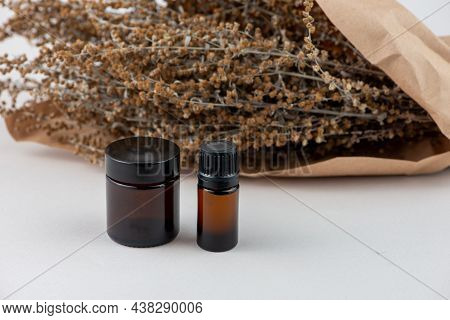 Dried Wormwood Herb, Artemisia Absinthiu, And Glass Bottles Close Up.