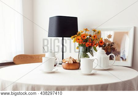 Round Table For Morning Fresh Tea With A White Tablecloth And Flowers Bouquet. Set For Tea-time. Ind