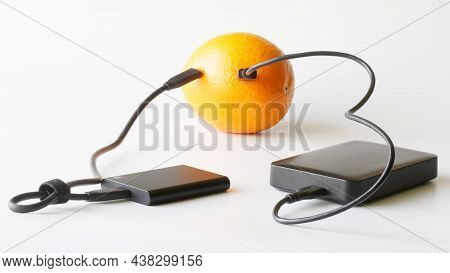 External Hdd And External Ssd Are Connected To Fresh Orange. Concept Of Green Technologies, Data Sto