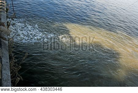 Dirty Orange Water From Sewage Pipeline Mixes With River Water.