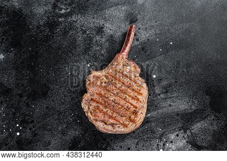 Bbq Grilled Tomahawk Beef Veal Steak On Butcher Table. Black Background. Top View