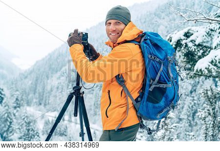 Smiling Man Dressed Orange Softshell Jacket With Backpack Photographing A Landscape Using Digital Ca