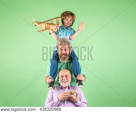 Boy Son With Father And Grandfather With A Toy Airplane Plays On Isolated Background. Family Adventu