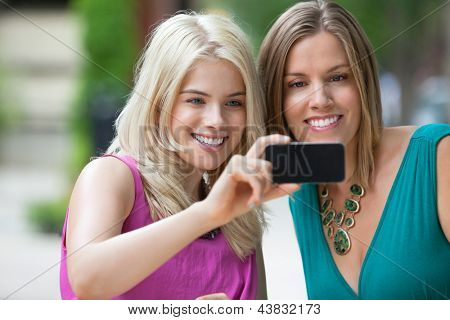 Happy friends femelles jeunes prenant un autoportrait avec téléphone portable