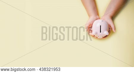 Little Boy Hand Holding Piggy Bank On Yellow Background, Saving, Charity, Family Finance Plan Concep