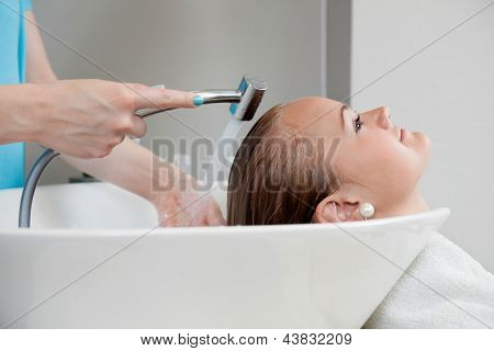 Boční pohled mladá běloška, jak jí vlasy umýt v beauty salonu