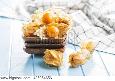 Physalis peruviana. Cape Gooseberry or ground cherries fruit on blue table.