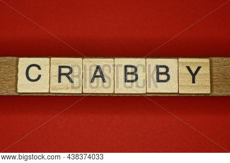 Text The Word Crabby From Gray Wooden Small Letters On An Red Table