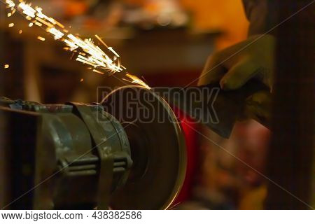 Sharpen The Knife On The Abrasive Wheel, Sparks Fly From Grinding Metal.