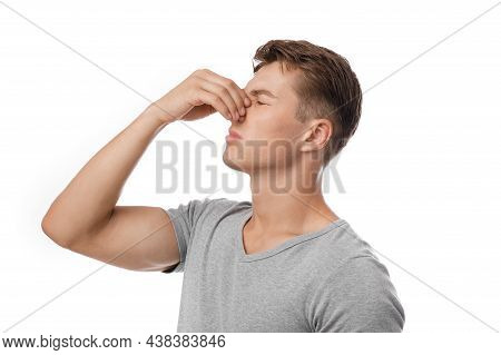 Sad Millennial Caucasian Attractive Guy Presses Hand To Nose, Suffers From Pain After Injury, Bleedi