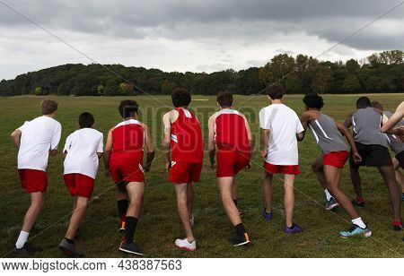 Rear View Of High School Boys Ready At The Starting Line Of A Cross Country Race On A Grass Field He