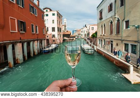 Drinking Wine Over Venice Embankments. Bar Visitor With Glass Of Prosseco Walking Past Old Houses Of